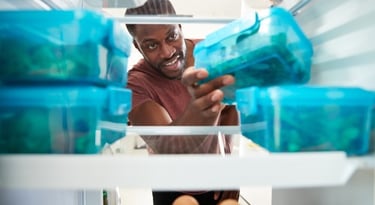a man is smiling and holding a food container