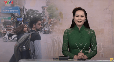An introduction of a news segment on VTV news. The image shows two foreigners walking around Hanoi, in Vietnam.