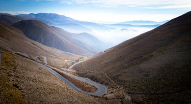 a winding road in the mountains with a view of the mountains