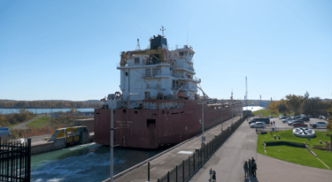 The stern of a red and white ship as it exits Lock 3 at the Welland Canal.