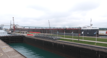 Huge freighter American Century slowly eases into the Poe Lock. MacArthur Lock is in the foreground.