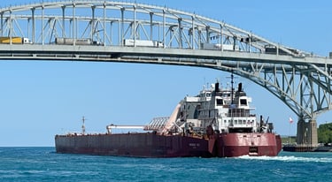 Huge red tug barge Presque Isle passes under the Blue Water Bridge.