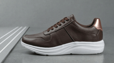 Zapato deportivo marrón oscuro con textura granulada y suela deportiva blanca