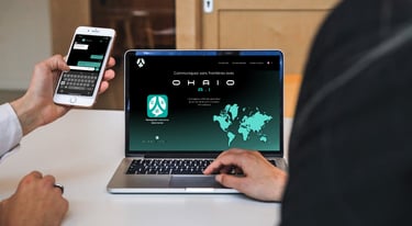 a man is holding a cell phone and a computer using ohaio chat