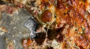 Homemade cheesy lasagna with golden brown crust, melted cheese, and savory meat sauce in a glass baking dish.