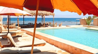Beach pool with lounge chairs and umbrellas