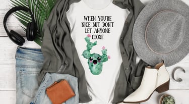 Plant-themed graphic tees and cozy hoodies displayed flatlay with jeans, boots, and greenery — Miss Chatty Plants apparel.