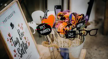 des accessoires de photobooth dans un pot pour les invités et une pancarte invitant à prendre un sel
