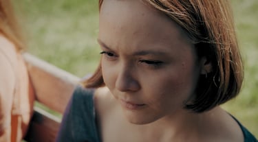 a woman sitting on a bench in a park