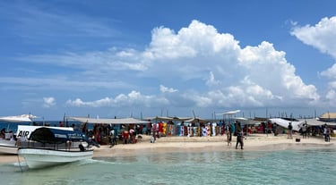 Tourists enjoying Nakupenda sandbank with traditional boat anchored in crystal-clear waters, Zanzibar, Tanzania