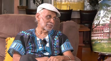 Clive Nunez actor in living room speaking on set of Legacies – The Series. Caribbean television scen