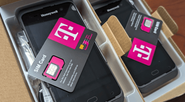T-Mobile SIM cards sitting on top of new Honeywell mobile handheld scanners in boxes.
