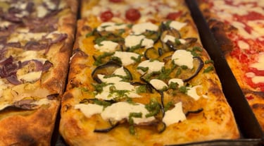 Selezione di pizze al taglio con ingredienti diversi da OTTO Pizza Milano