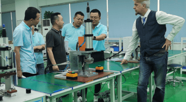 a man standing in a factory with a machine