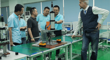 a man standing in a factory with a machine