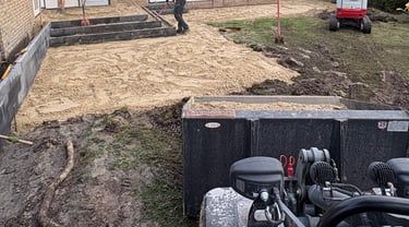 Betsema Bestrating aan bezig met grondwerk in een tuin.