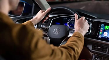 Bild eines Studenten am Steuer eines VW-Autos, der Fahrunterricht erhält oder übt.