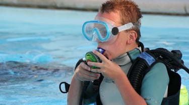 a boy in a diving suit and goggles in the water