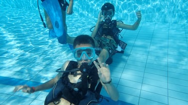 a group of people in scuba gear in a pool