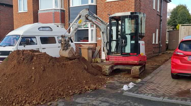 Micro digger digging footings in a Kings Norton driveway