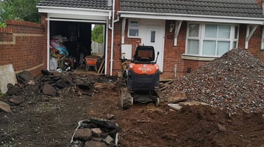 mini digger and wheel barrow outside a house in west brom