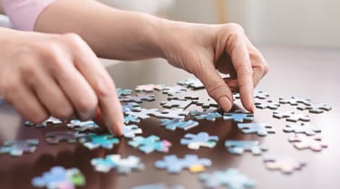 Two hands putting together a puzzle