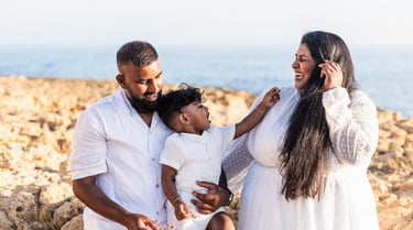 a family of three people standing on rocks