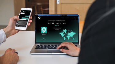 a man is holding a cell phone and a computer using ohaio chat