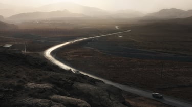 a car driving down a winding road in the mountains