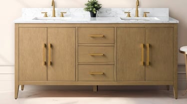 Light oak wood double bathroom vanity with a white marble top and gold hardware.