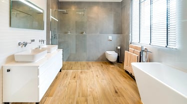 Nowoczesna łazienka z wanną, prysznicem, dwiema umywalkami i drewnianą podłogą