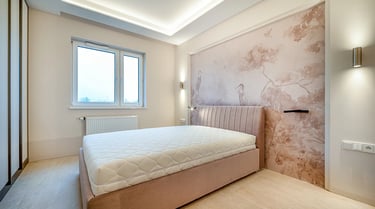 Sypialnia z łóżkiem i materacem, tapicerowany zagłówek, ściana z tapetą w ptaki, okno i oświetlenie 