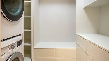 Nowoczesna garderoba z zabudową, półkami i szafkami, drążkiem na ubrania oraz pralką i suszarka