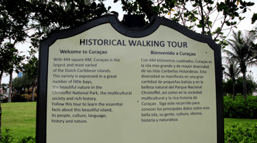 Placa informativa do Historical Walking Tour em Willemstad, Curaçao, destacando pontos históricos.
