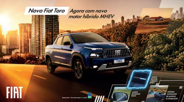 Blue Fiat Toro pickup truck with new MHEV hybrid engine driving through a modern city at sunset.