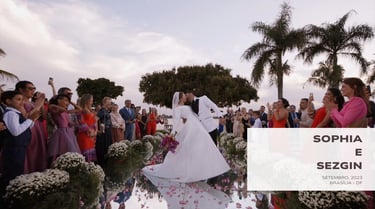 Beijo dos noivos em cerimônia ao ar livre em Brasília, rodeados por convidados e flores.