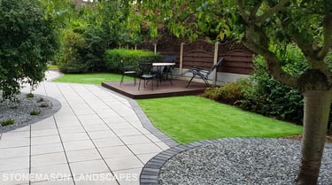 Patio with custom stone circle with aggregates and paving weaving through adventurous garden design