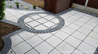 Patio with custom stone circle with aggregates and paving weaving through adventurous garden design
