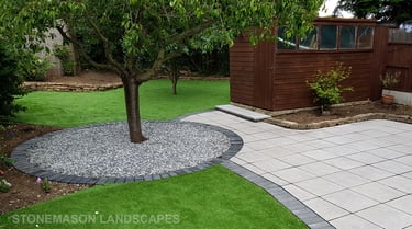 Patio with custom stone circle with aggregates and paving weaving through adventurous garden design