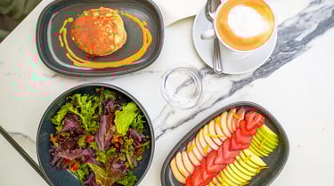 a table with a plate of food and a cup of coffee