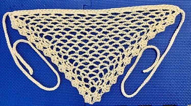 Crochet bandana belt in a natural color laid out flat showing lacy stitches