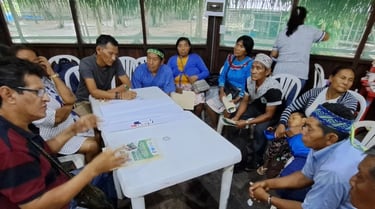 Indigenous community members gather around a table for a collaborative workshop and discussion.