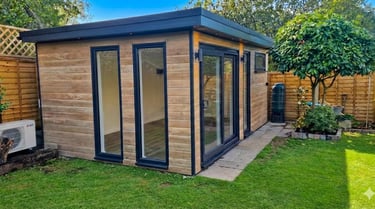 Modern cedar effect garden room with black trim and sliding glass doors