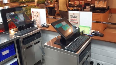 Two touchscreen POS stations in a high-volume cafeteria-style serving line