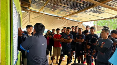 Soccer team members of Roger Bardales Mokanranko team in uniforms gather under a tin roof