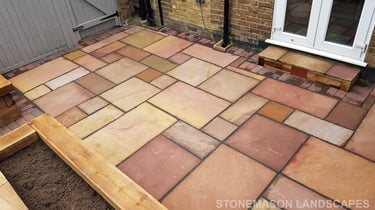 Colourful sandstone patio with raised wooden timber planter seating