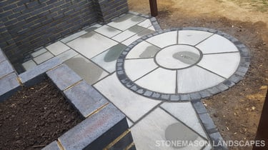 Grey sandstone circle paving slabs with charcoal edging