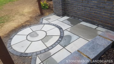 Grey sandstone circle paving slabs with charcoal edging