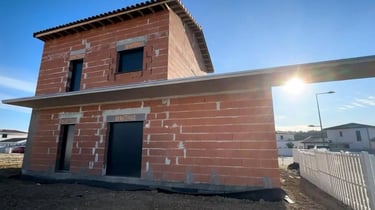 a house with a brick wall and a small house