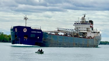 Great Lakes freighter Algoma Compass passing a small fishing boat.